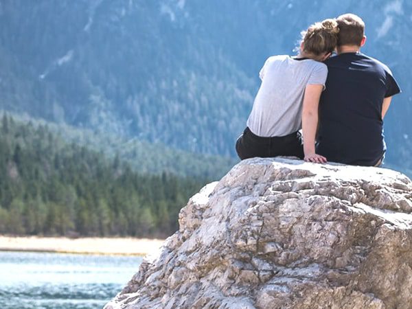 a couple is sitting on the stone